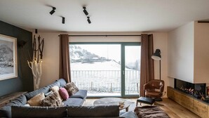 Un salon moderne avec un canapé, un fauteuil et une cheminée.