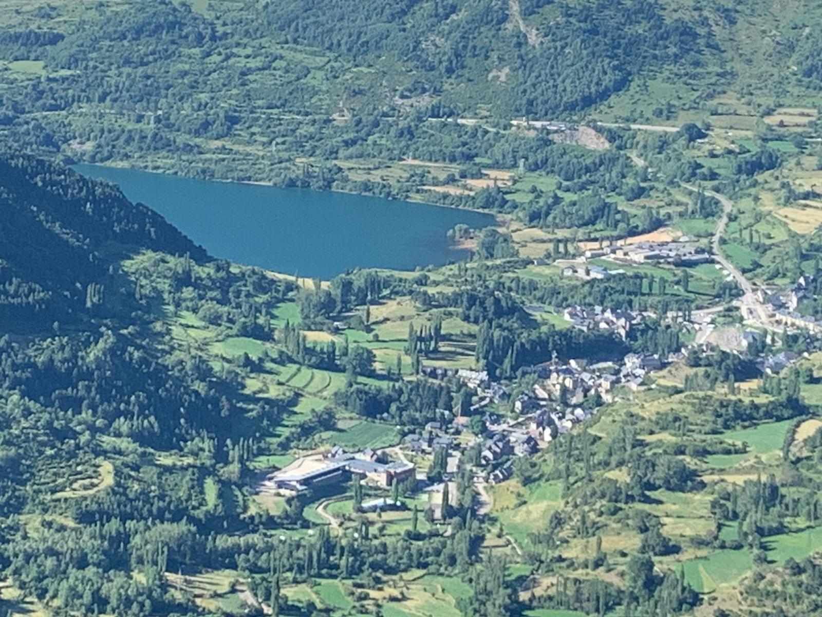 A mountainous landscape with a small village and a lake.
