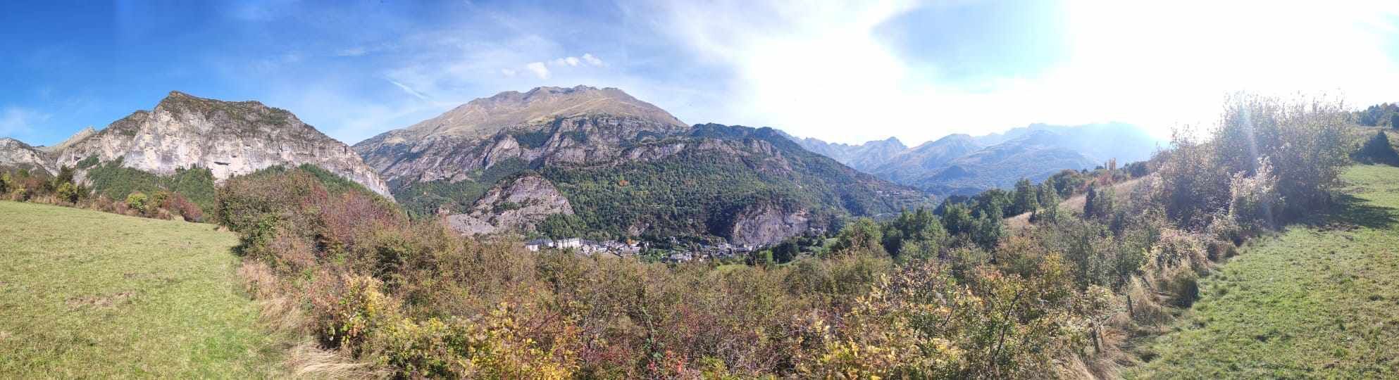 A mountainous landscape with a valley and a small settlement.