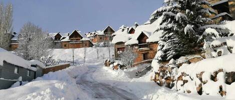 Un pueblo cubierto de nieve con casas de madera y un cielo despejado.