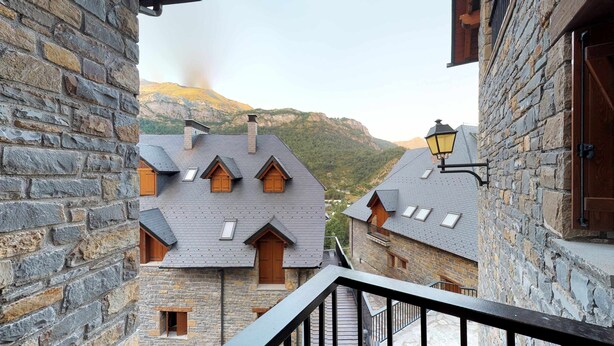 A stone building with multiple windows and a balcony.