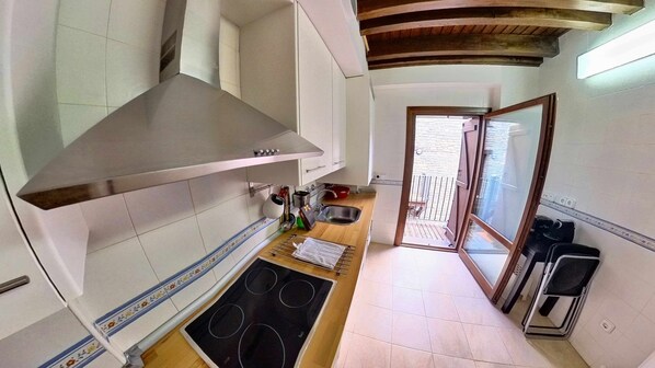 A compact kitchen with a stainless steel range hood, a built-in oven, and a small sink. - Bright Penthouse - tucasaenlospirineos (Escarrilla)