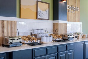A breakfast buffet with various pastries, a toaster, and coffee mugs. - Spark by Hilton Dumas (Dumas)