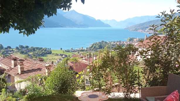 A patio with wicker furniture and a view of a lake and mountains. - Las tres tajanas Apartment (Gravedona Ed Uniti)