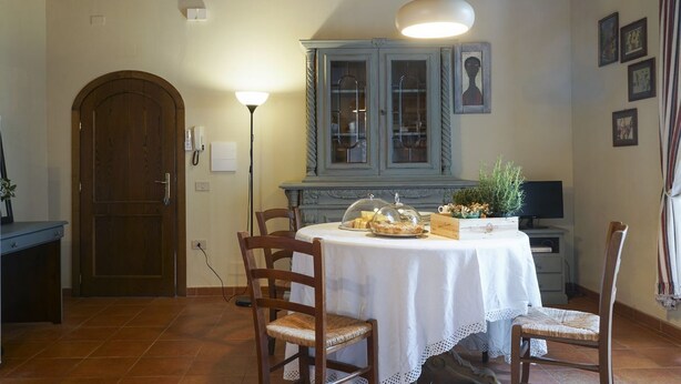 Un comedor con una mesa redonda, sillas, un armario y una puerta.
