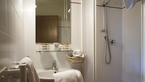 Un baño con lavamanos, espejo y ducha.