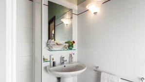 A bathroom with a white sink, mirror, and towel rack. - Elegant apartment with pool view near the Spa (Sassetta)