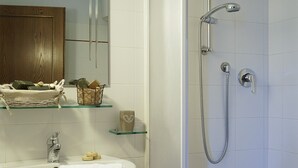 Une salle de bain avec un lavabo, un miroir et une douche.