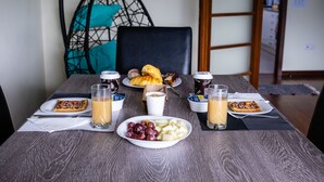 Et morgenbord med croissanter, et fad med frugt og to glas appelsinjuice.