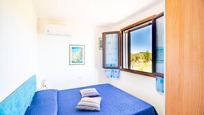 Une chambre à coucher avec un lit, une fenêtre et un tableau au mur.