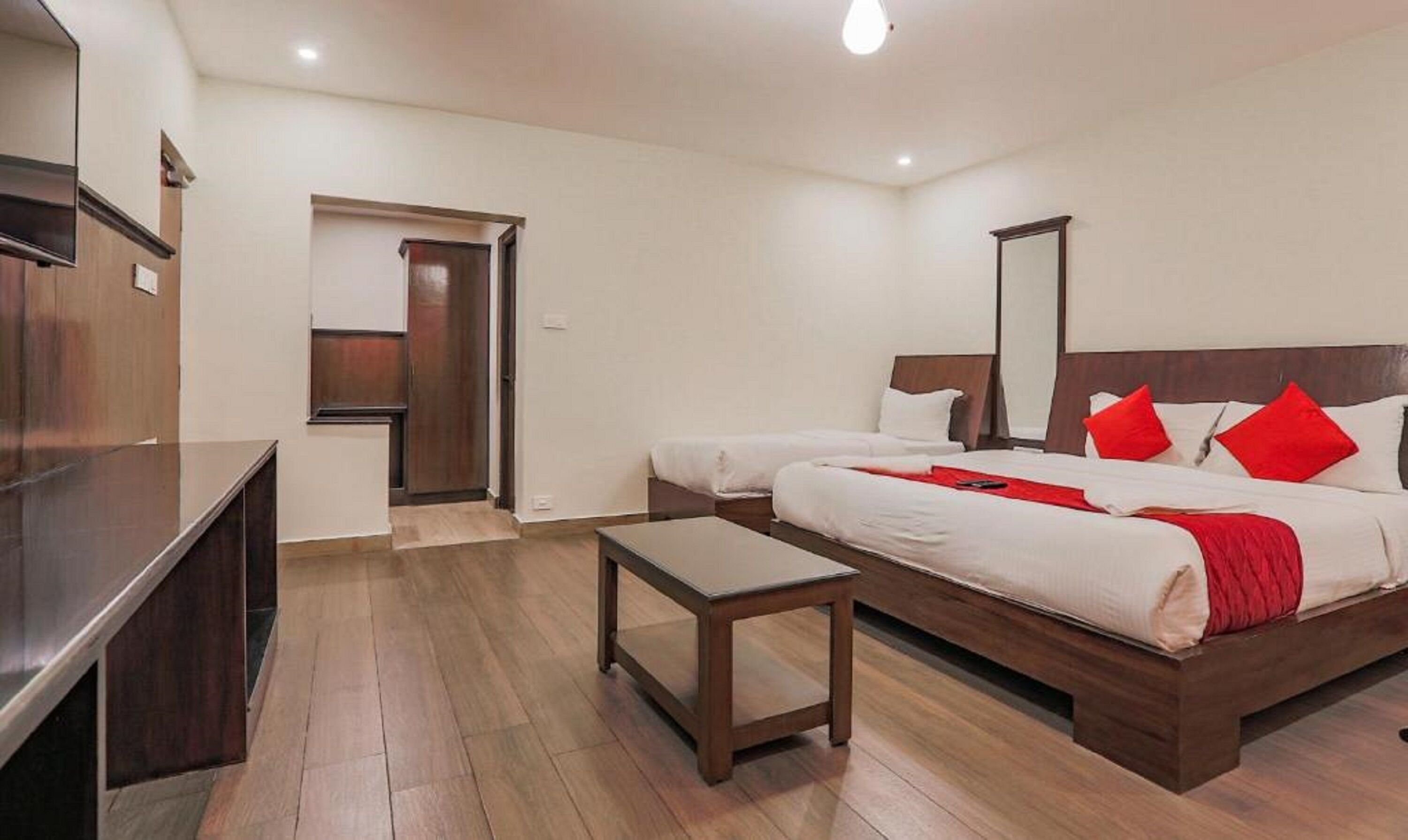 A hotel room with a bed, bedside table, and a TV.