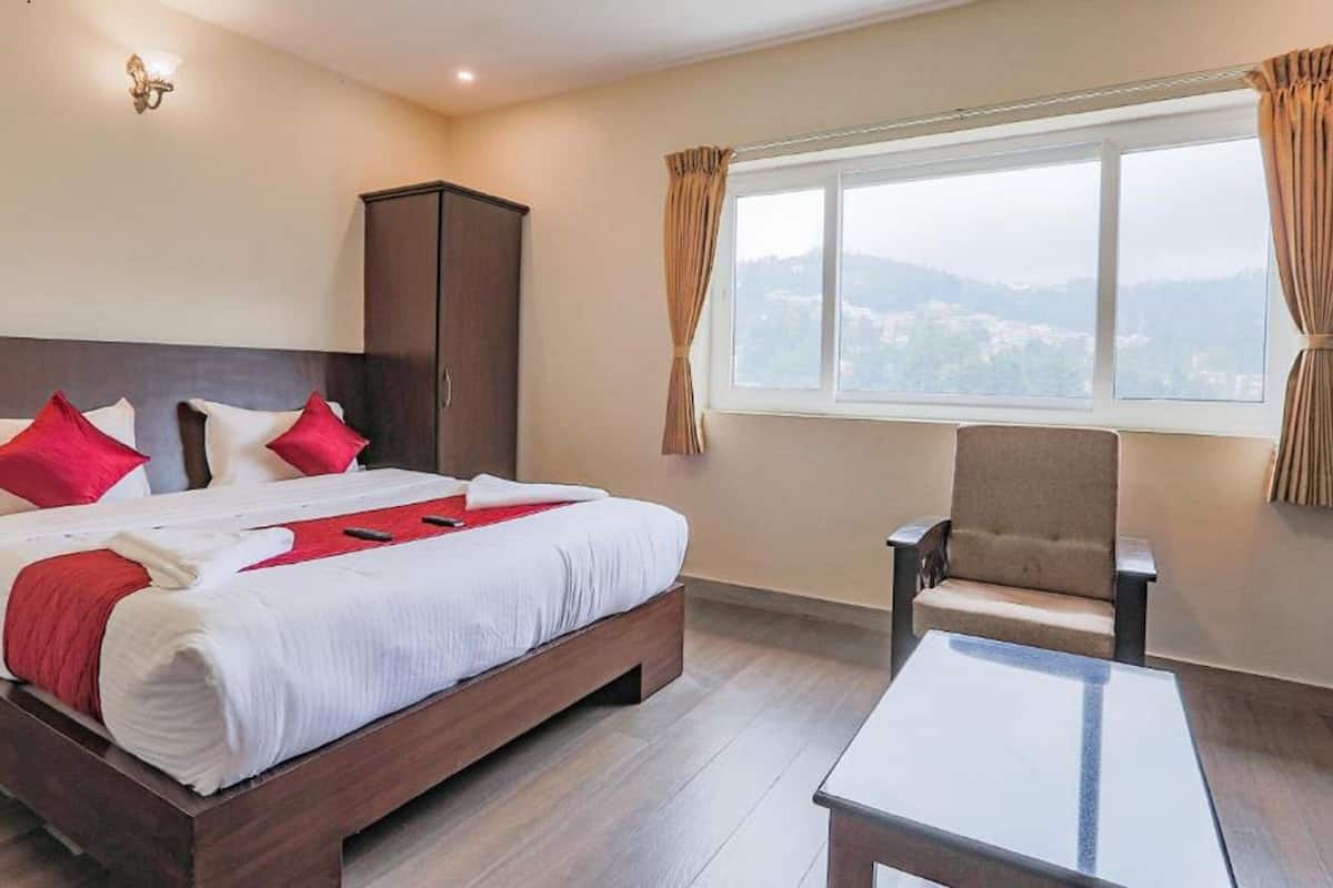 A hotel room with a bed, a chair, a wardrobe, and a window with a view.