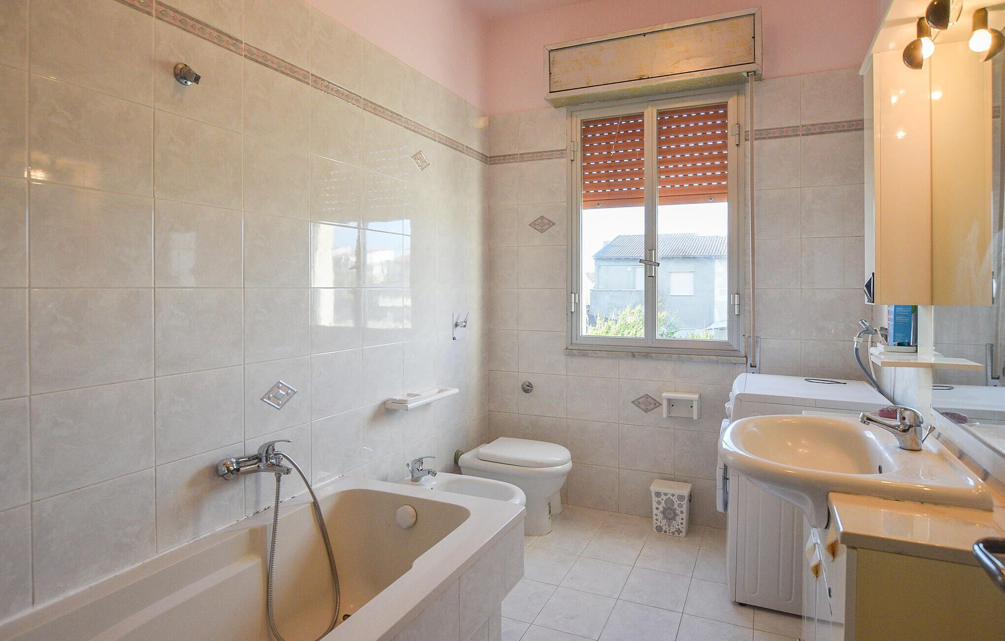 A bathroom with a bathtub, toilet, and sink.