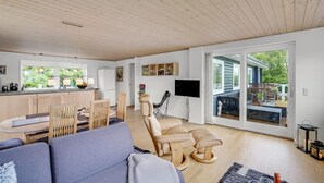 Uma sala de estar moderna com sofá, área de jantar e cozinha.