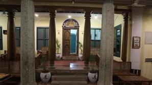 A traditional building with a central entrance, flanked by columns, leading to a staircase. - Saradharam Heritage Hotel Lakshmi Vilas (Kattumannarkoil)