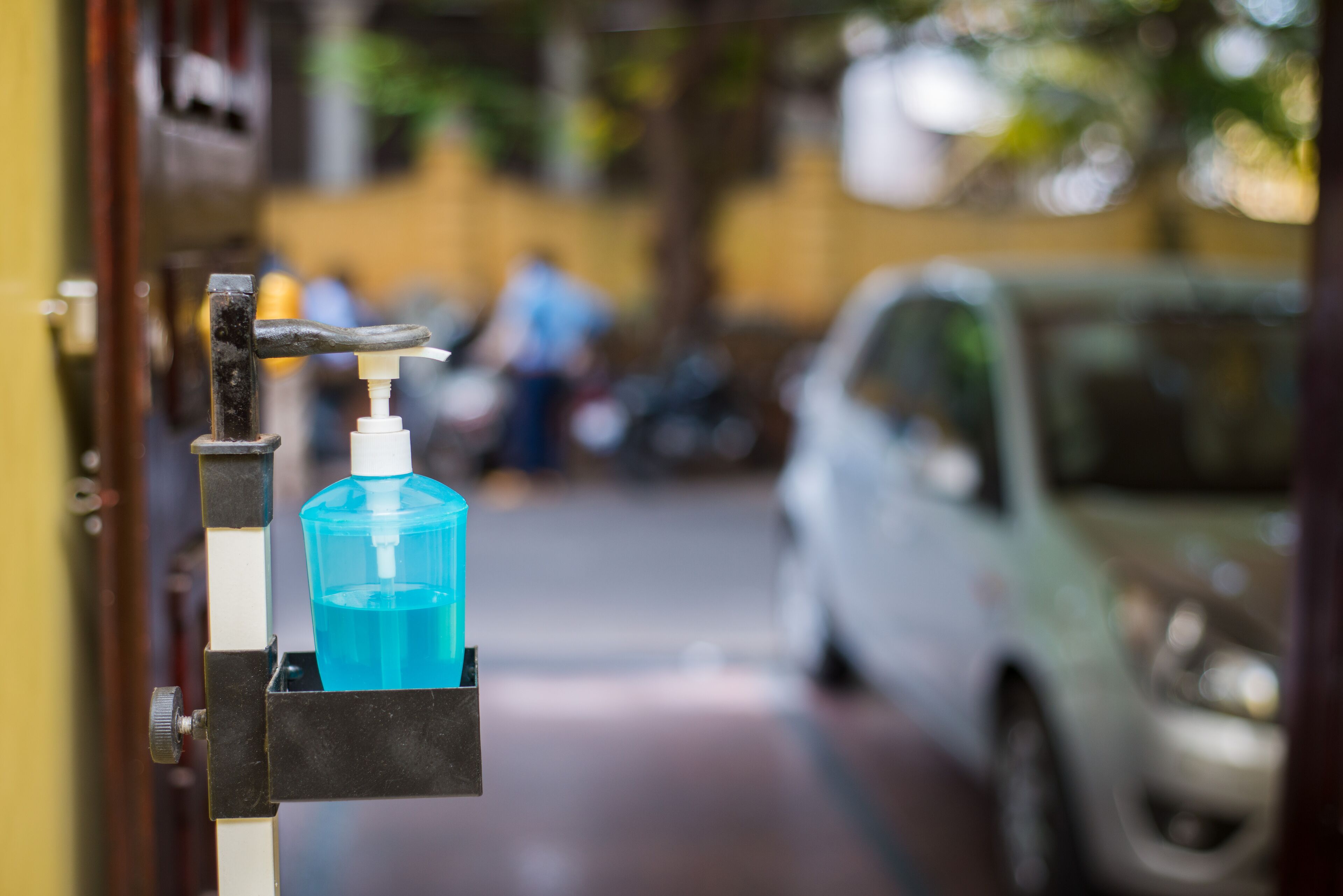 A hand sanitizer dispenser mounted on a door handle.