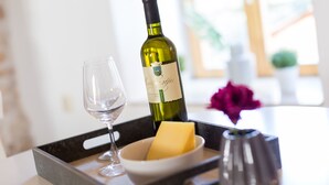 A tray with a wine bottle, a glass, a bowl with a yellow object, and a vase. - DeAmicis Studios by Irundo (Rovinj)
