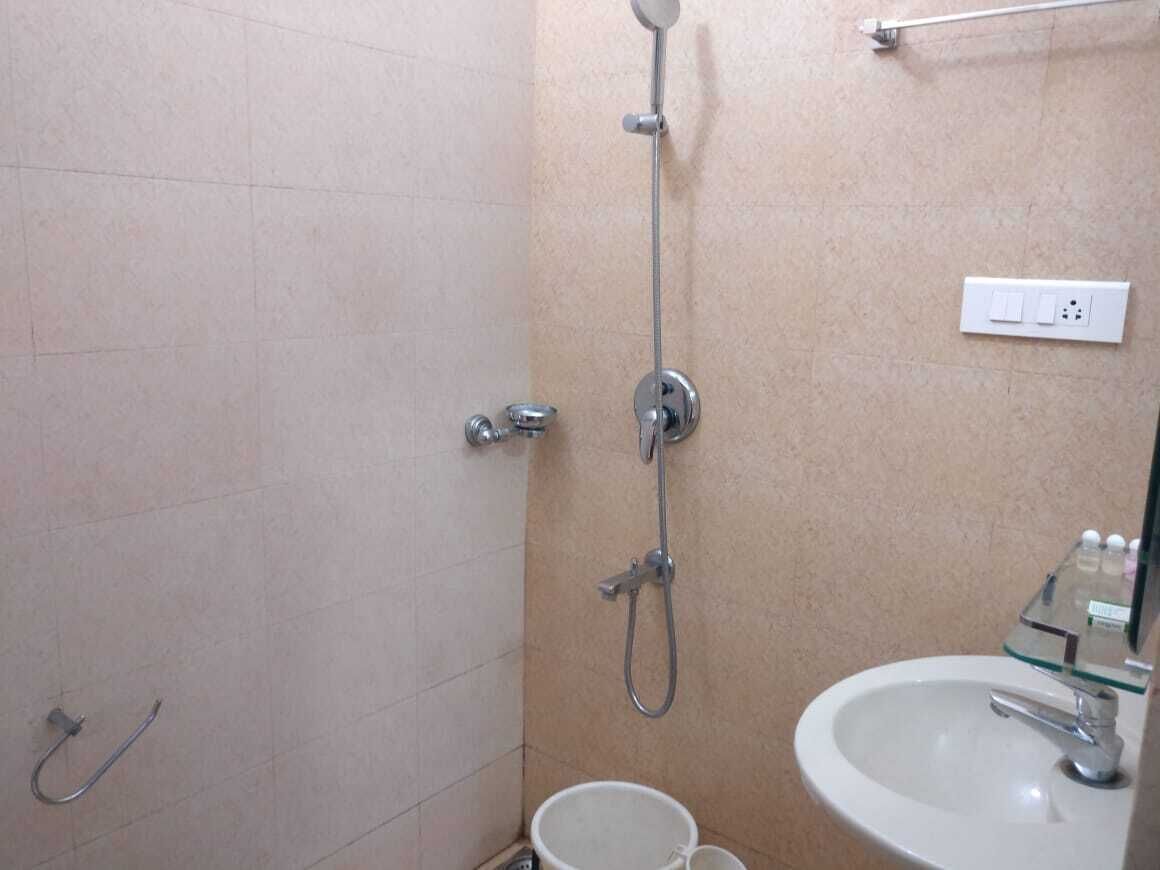 A bathroom with a shower, a sink, and a glass shower enclosure.