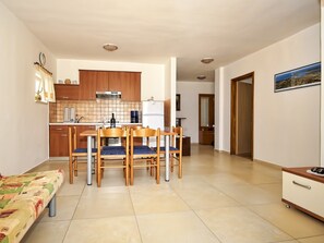 A compact living space with a dining area, kitchenette, and a bed. - Apartments Snjezana (Medulin)