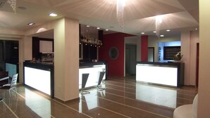 Une cuisine moderne dotée de deux îlots, d’un coin bar et d’un espace détente avec une chaise blanche.