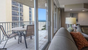Un balcone con tavolo e sedie, un divano e una lampada.