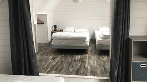 A bedroom with a bed, a nightstand, and a dresser.