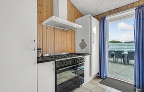 Enjoy cooking in this well-equipped kitchen with a gas stove and oven, leading to an outdoor patio with a view.