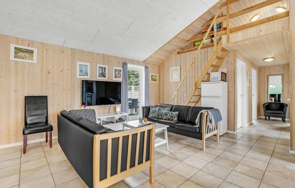 Relax in this inviting living space with a large flat-screen TV, comfortable sofa, and stylish coffee table.