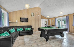 Relax and unwind in this inviting space, featuring a pool table, comfortable sofa, and flat-screen TV.