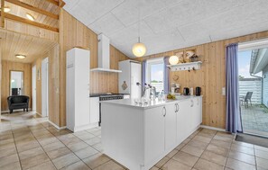 Enjoy cooking in this spacious kitchen with a central island, stainless steel range hood, and large window offering a view of the outdoors.