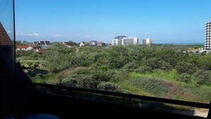 A view from inside a building, overlooking a landscape with residential houses and modern high-rise buildings.