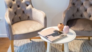 Two tufted armchairs, a white round table with a book and two vases, and a patterned rug. - Cozy Montalbano Studios by Irundo (Rovinj)