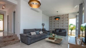 A modern living room with two grey sofas, a glass coffee table, and a patterned wall. - Holiday home Villetta Belveder (Baska Voda)