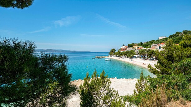 A coastal view with a beach, boats, and houses on a hillside. - Holiday home Villetta Belveder (Baska Voda)