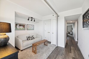 Un salon moderne avec un canapé, une table basse et des œuvres d’art accrochées au mur.