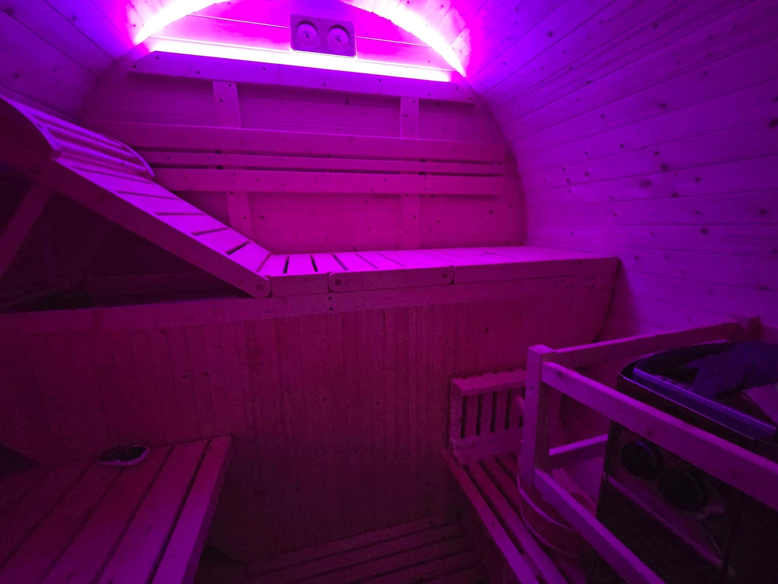 A sauna with wooden benches and a sloped ceiling.
