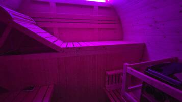 A sauna with wooden benches and a sloped ceiling.