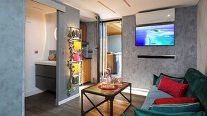 Un soggiorno moderno con un divano, un tavolino da caffè e una TV che mostra un panorama.