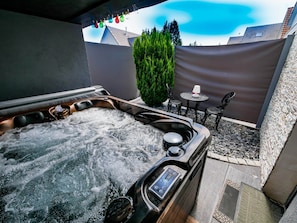 A hot tub with a control panel, surrounded by outdoor seating and a decorative hedge. - Design studio, jacuzzi, private terrace, air conditioning (Furdenheim)
