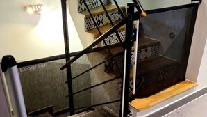Uma escadaria moderna com guarda-corpos de vidro e degraus estampados.