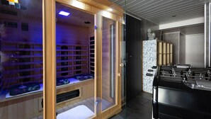 Quarto com sauna, mesa de pebolim e parede estampada.