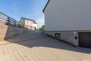 A paved pathway leading to a building with a garage door, a wooden fence, and a clear sky. - Villa 250m² with private spa, barbecue, table football (Hurtigheim)