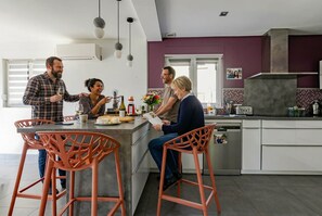 A modern kitchen with a central island, bar stools, and a dining area with a window. - Villa 250m² with private spa, barbecue, table football (Hurtigheim)