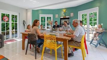 Un espace repas comprenant une table ronde, des chaises et un écran de télévision.