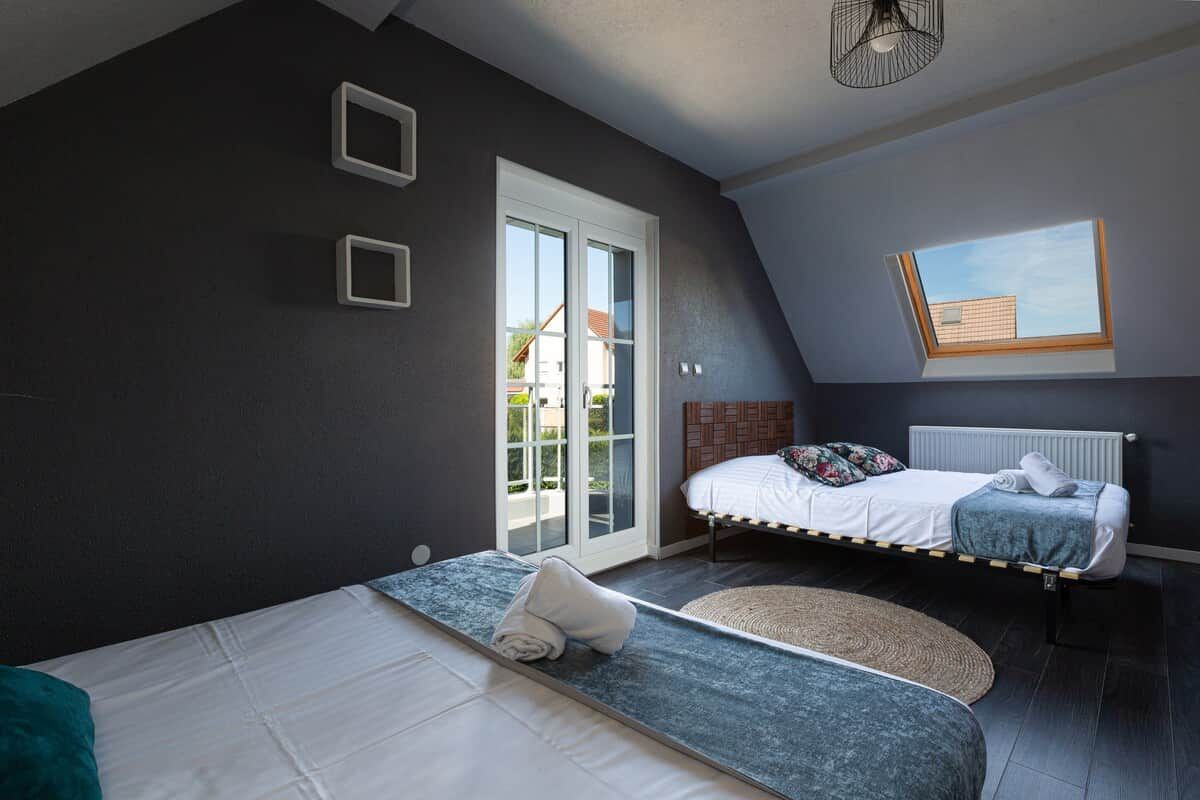 Een slaapkamer met een bed, een raam en een dakraam.