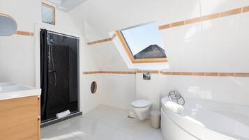Une salle de bain moderne équipée d’une douche, de toilettes et d’une baignoire.
