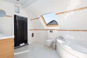 Un bagno moderno dotato di doccia, WC e vasca da bagno.