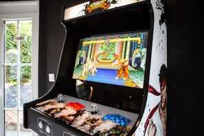 Una máquina de videojuegos antigua con una pantalla mostrando un juego, un joystick y botones.