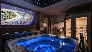 Een wellnessruimte met een bubbelbad, een schilderij aan de muur en een houten bank.