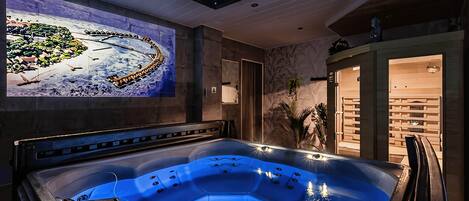 A spa area with a hot tub, a wall-mounted painting, and a wooden bench.